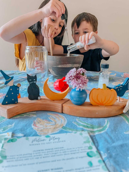 2 children playing with sensory potion kit at table